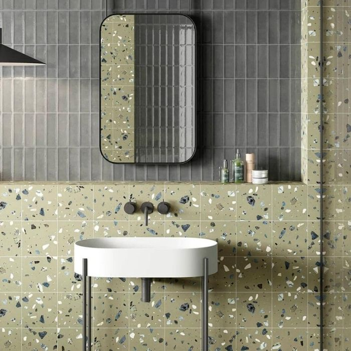 Terrazzo and grey tiles behind a bathroom sink