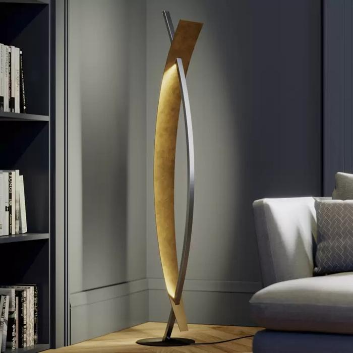 Curved floor lamp with golden inner surface next to sofa