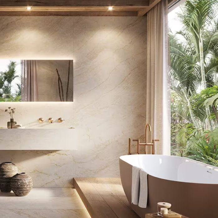 Freestanding bathtub with marble wall tiles and wood flooring