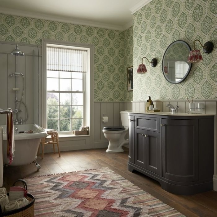 Country bathroom with green wallpaper and wood flooring