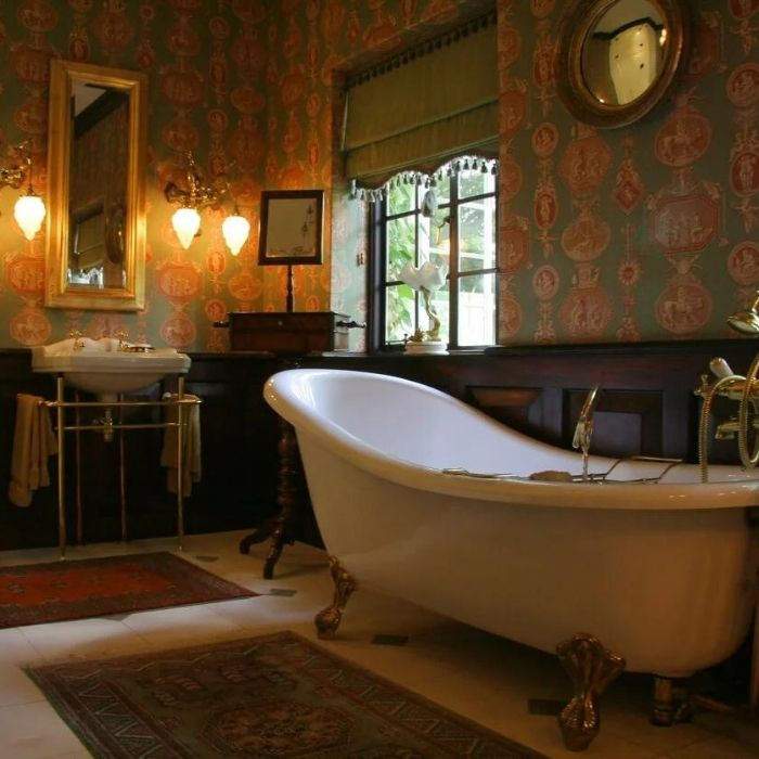 Victorian bathroom with dark wallpaper and clawfoot bath