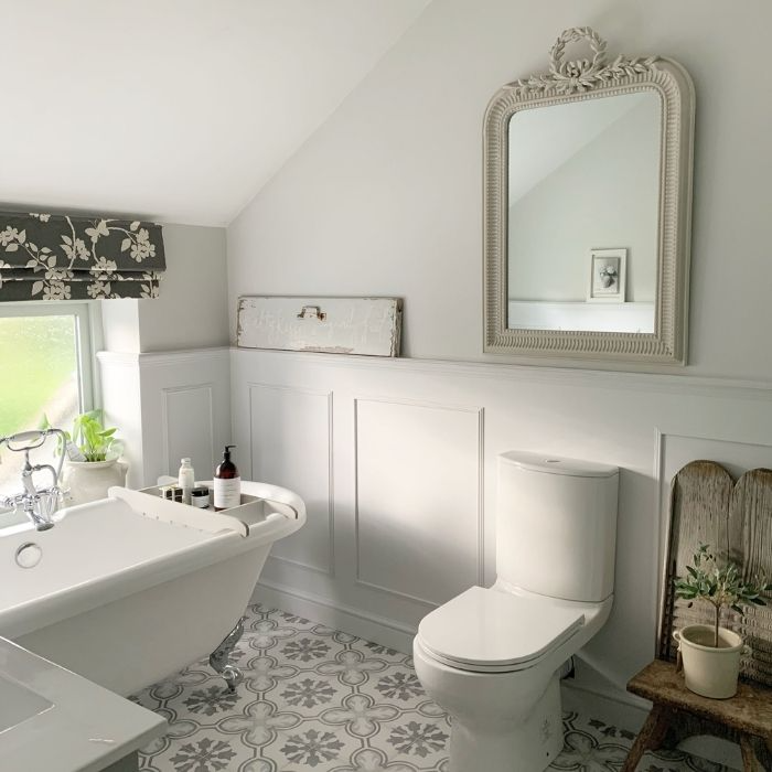 Country bathroom with grey wainscoting and floral-patterned floor tiles