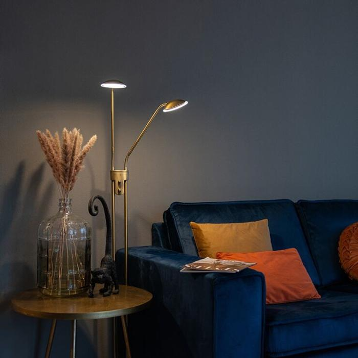 Brass floor lamp next to blue sofa with colourful cushions