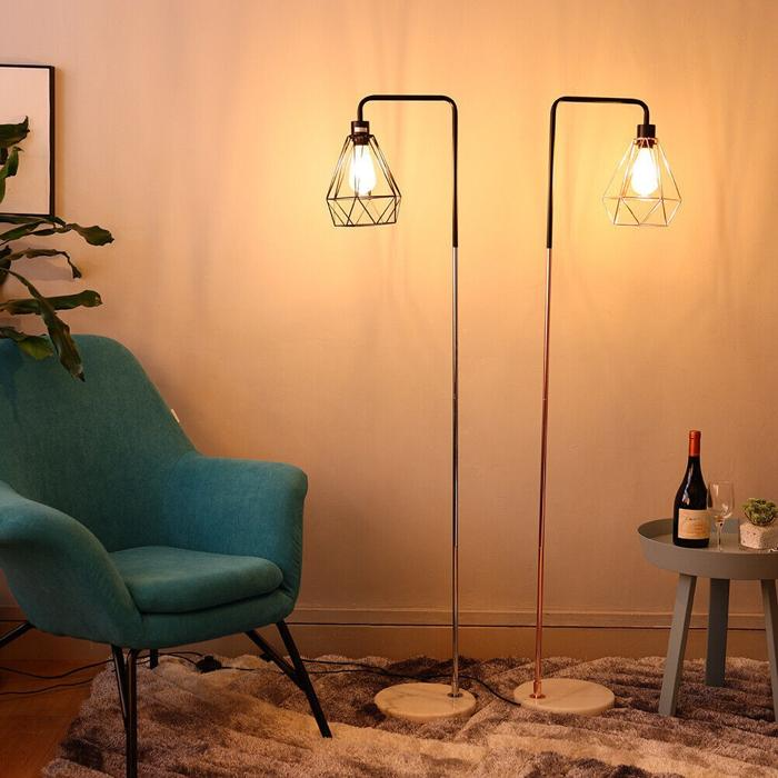 Two geometric floor lamps beside teal armchair