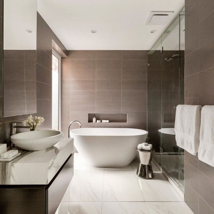 Modern bathroom with brown wall tiles and freestanding tub