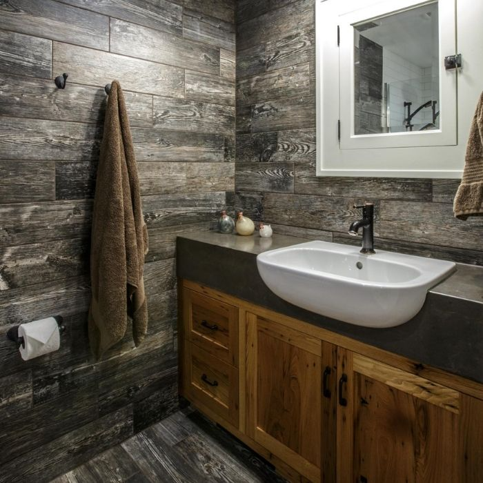 Rustic bathroom with weathered wood walls and a concrete sink