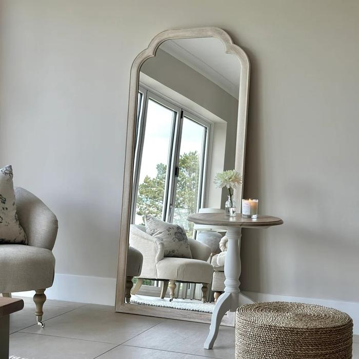 Stylish chair and floor lamp beside a tall mirror