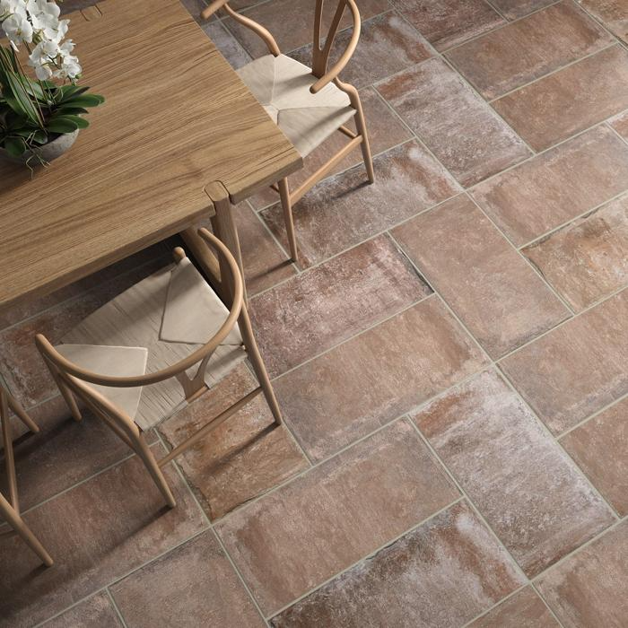 Dark terracotta tiles under a wooden dining table