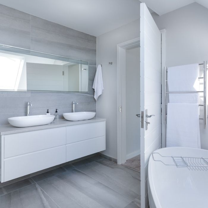 Grey tiles and white vanity in a spacious bathroom