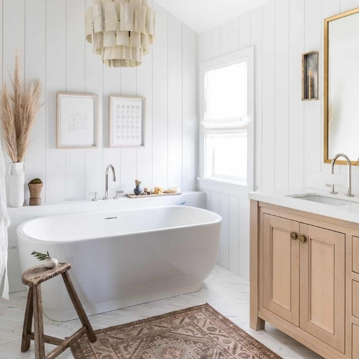 Freestanding tub with light wood vanity and soft lighting