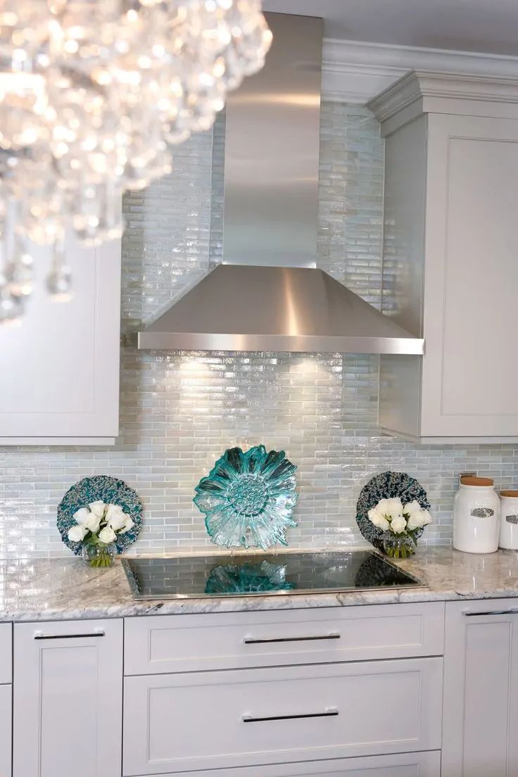 Elegant kitchen with glossy backsplash and artistic turquoise accents.