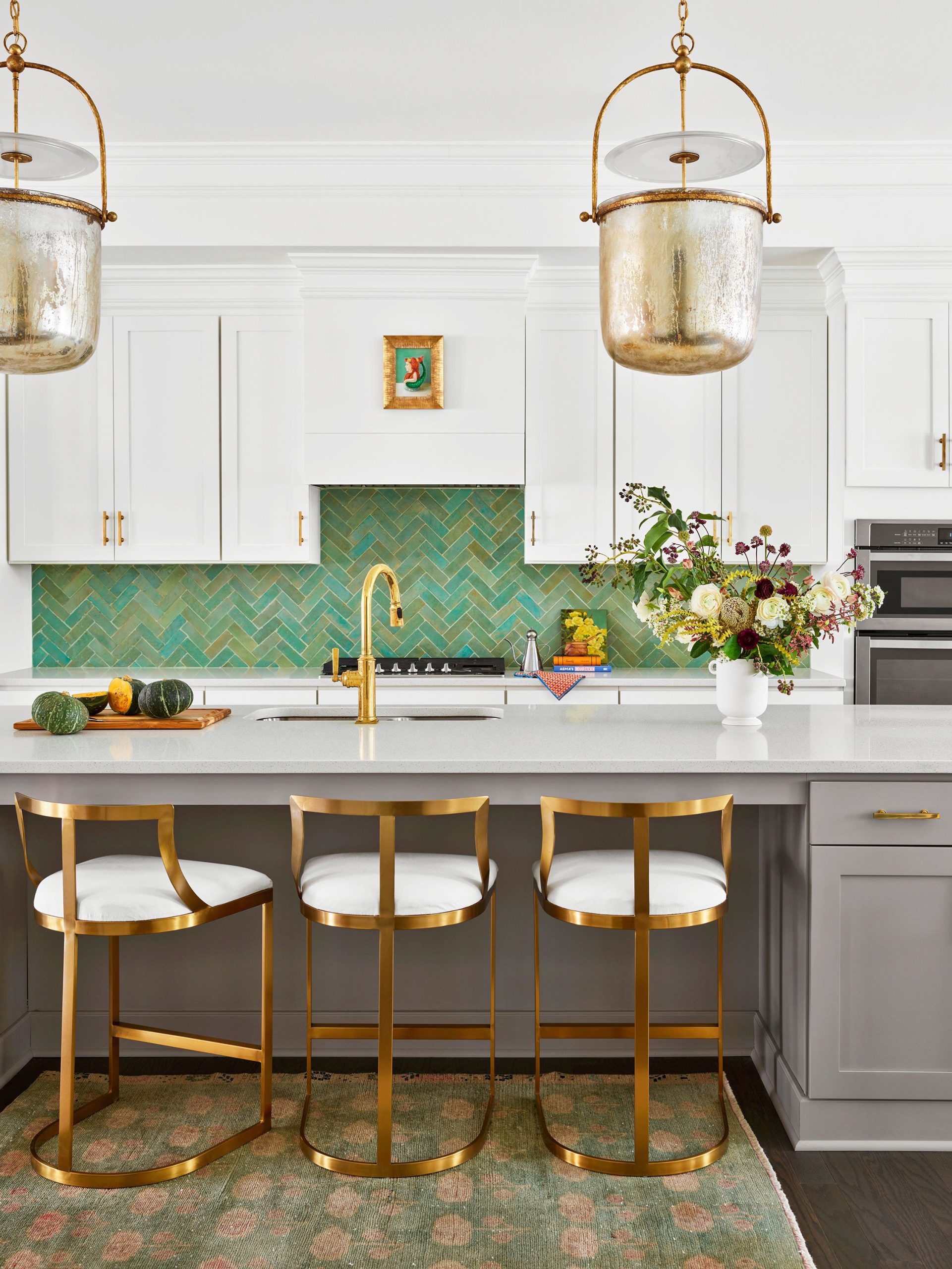 Elegant kitchen with green herringbone tiles and gold accents.
