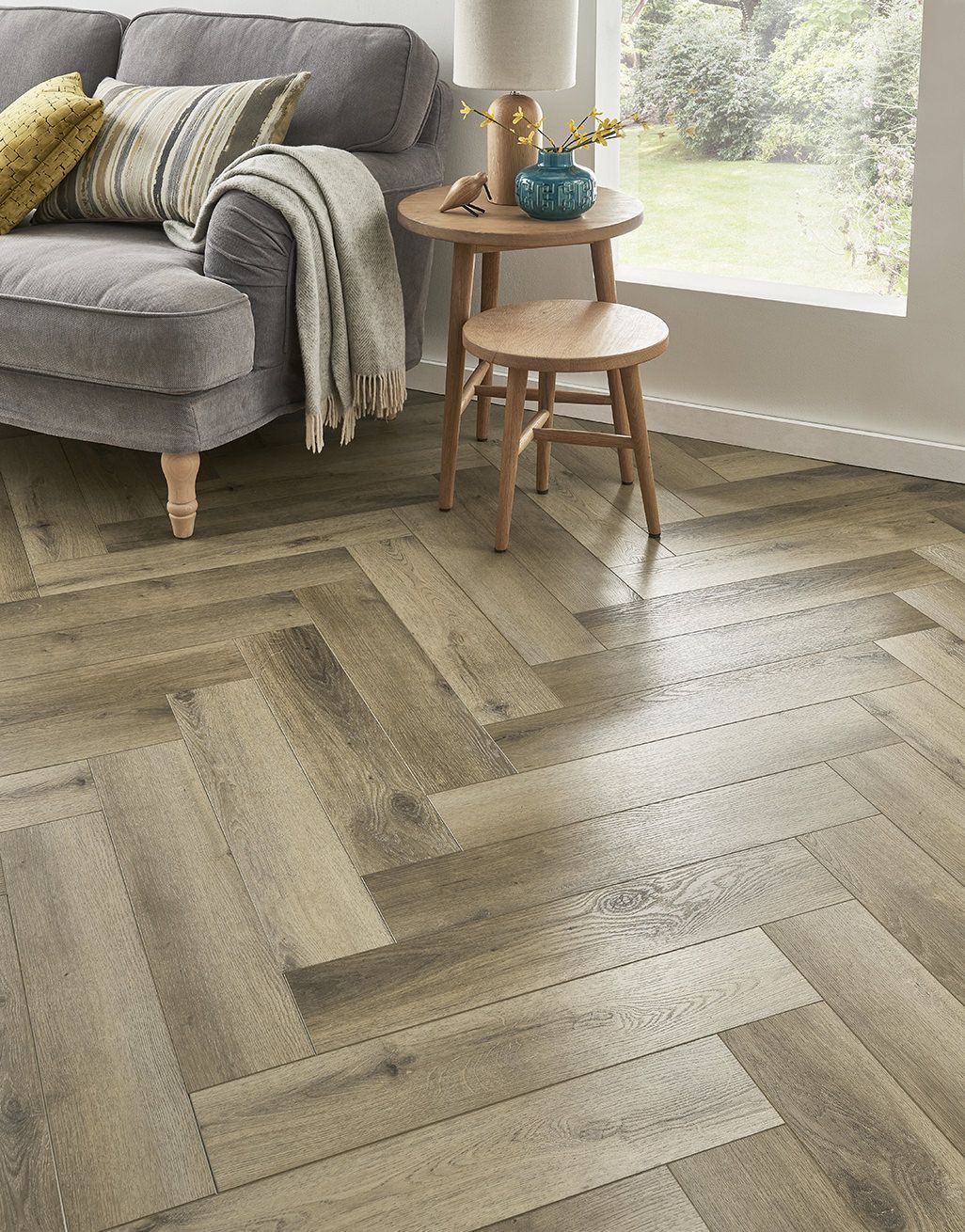 Elegant living room featuring stylish herringbone-patterned Evocore flooring.