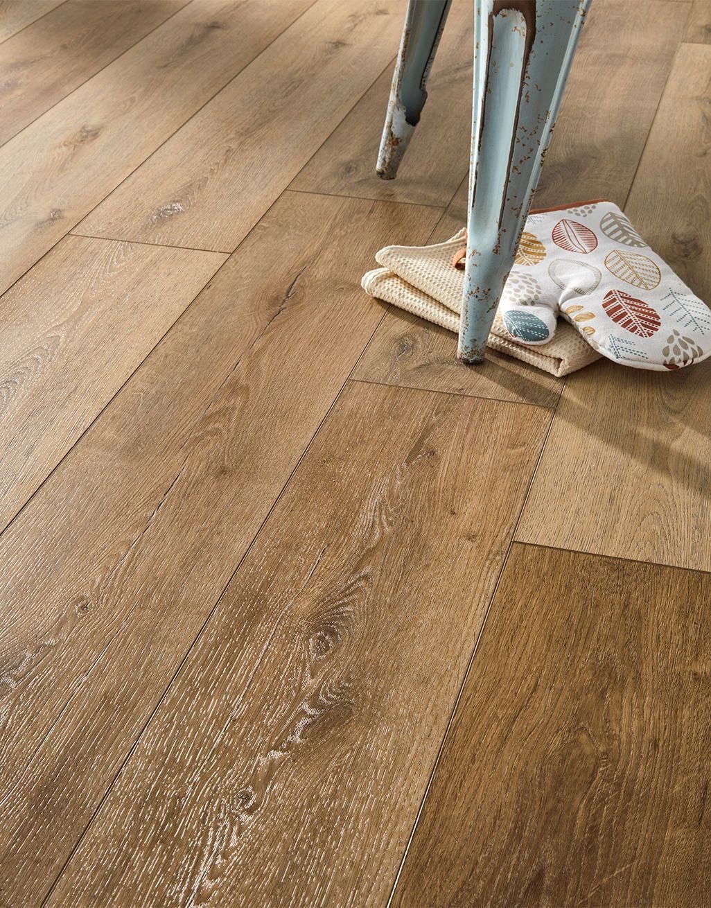 Rustic Evocore flooring with distressed chair and cozy textiles.