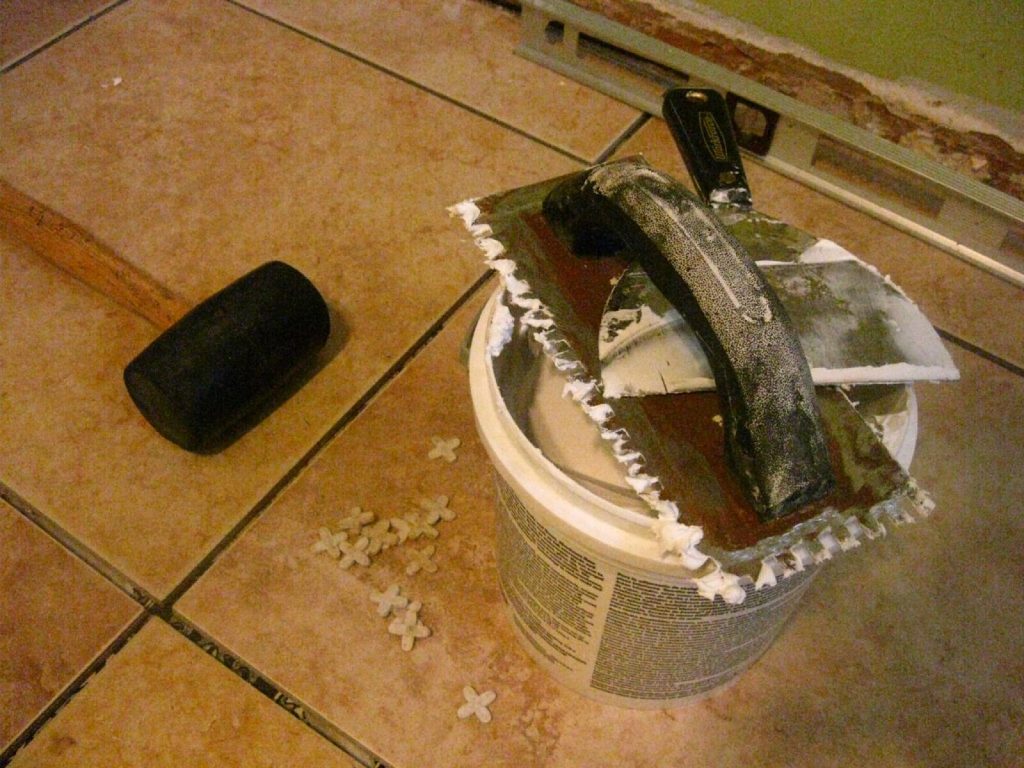 Tiling tools and spacers on a part-tiled ceramic floor