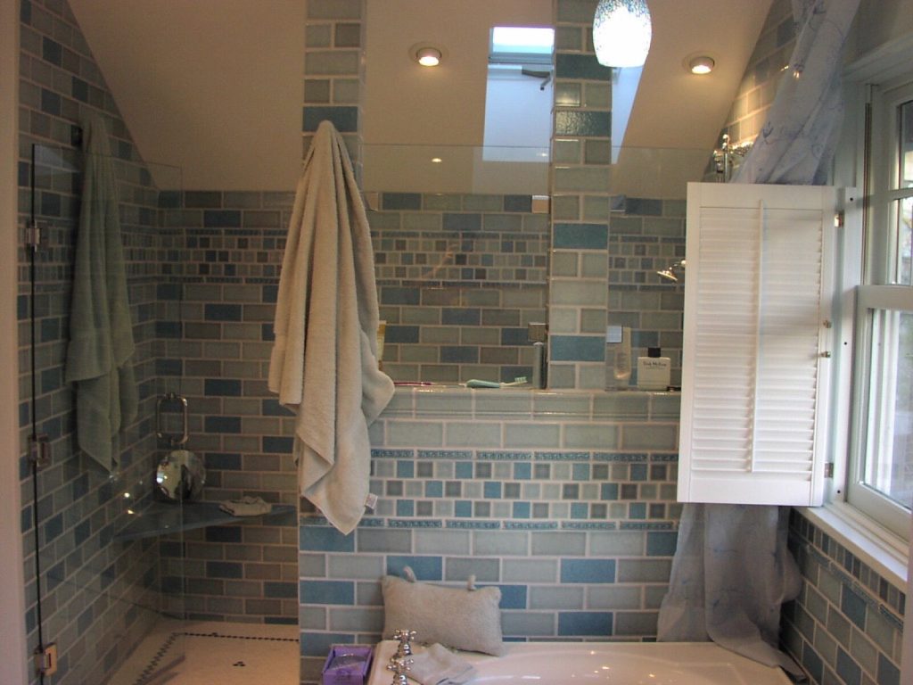 A tiled bathroom with blue tiling around the shower and bath