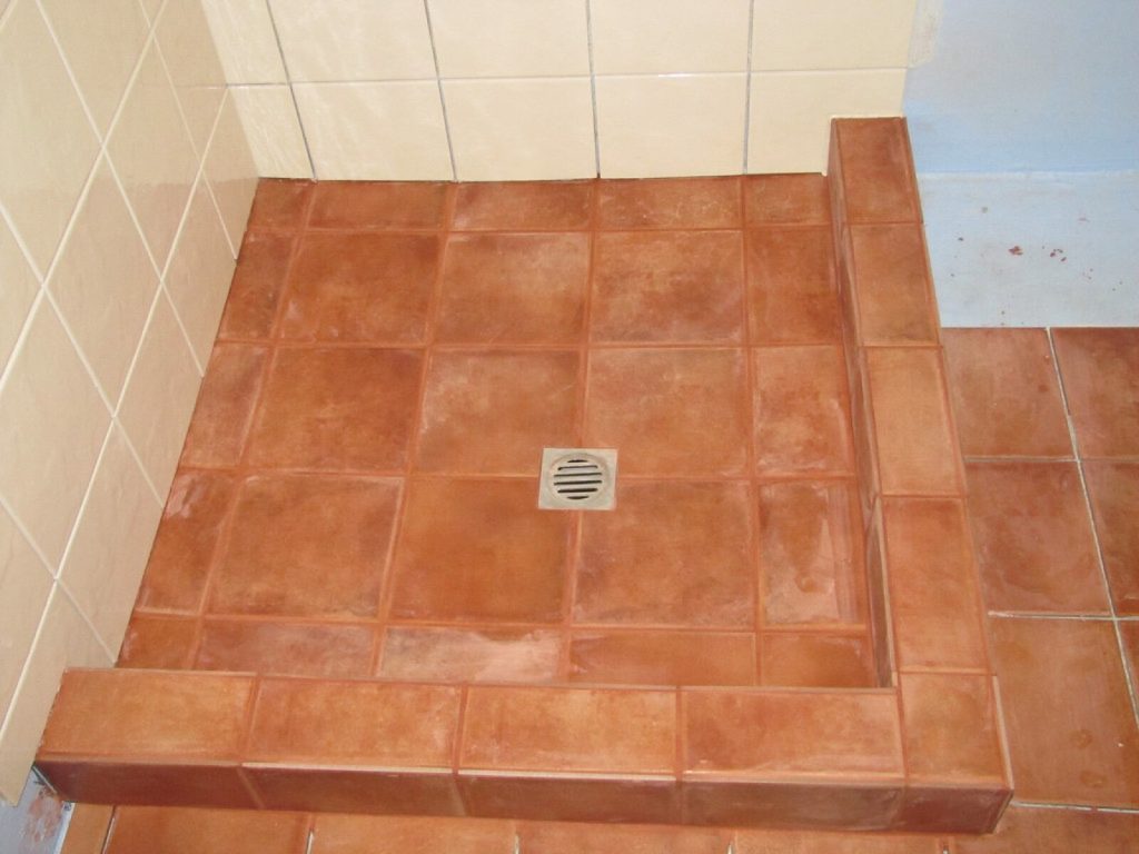Tiled shower floor with grout lines, where tile and grout problems commonly appear