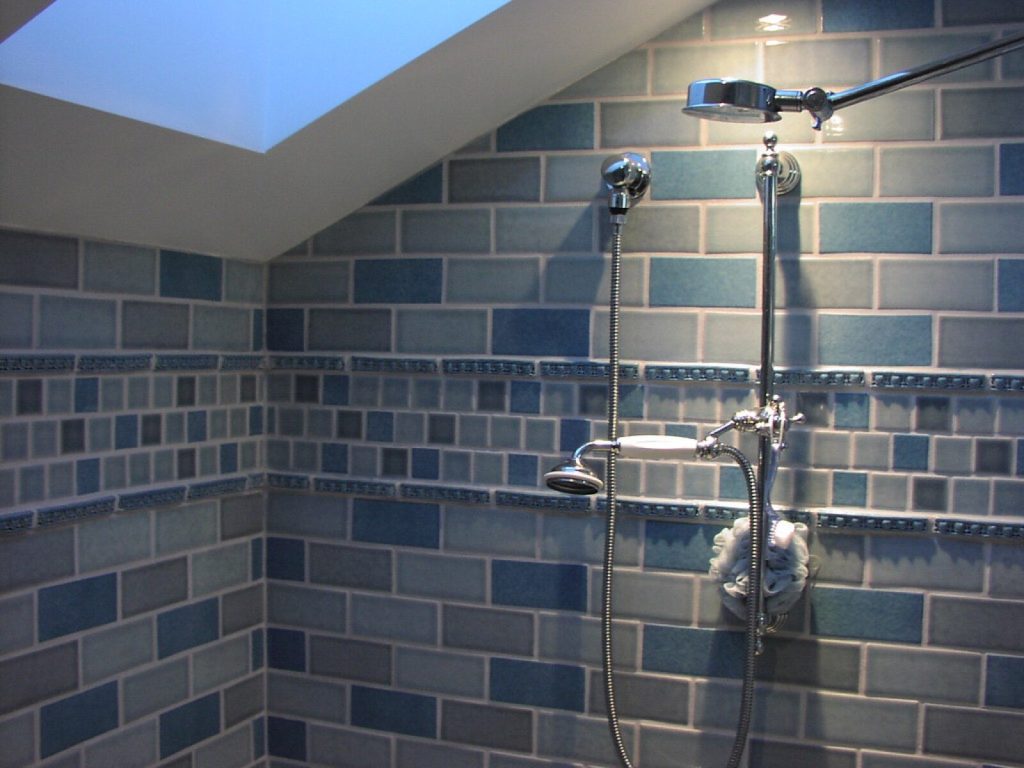 Tiled shower enclosure with brick-bond wall tiles and a chrome shower valve