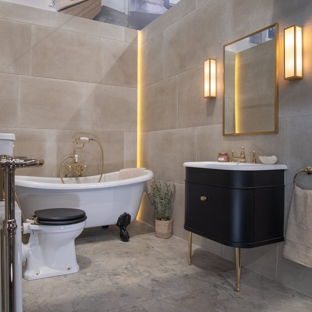 Large format stone-effect wall tiles behind a freestanding bath