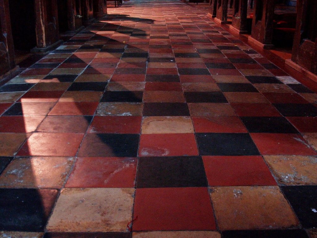 Red and black quarry tile floor in a church aisle