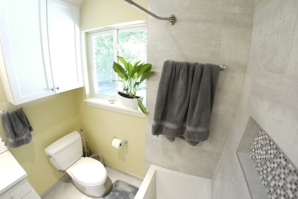 Tiled shower with a recessed niche lined with grey mosaic tiles