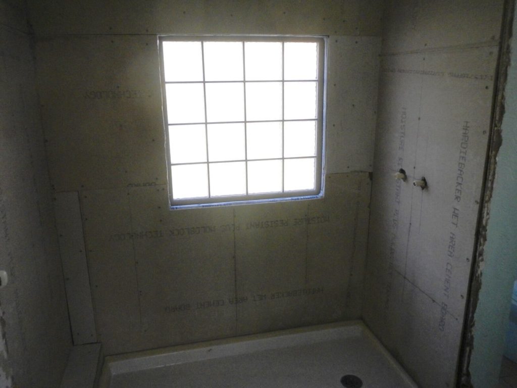 Shower enclosure walls lined with cement backer board before tiling