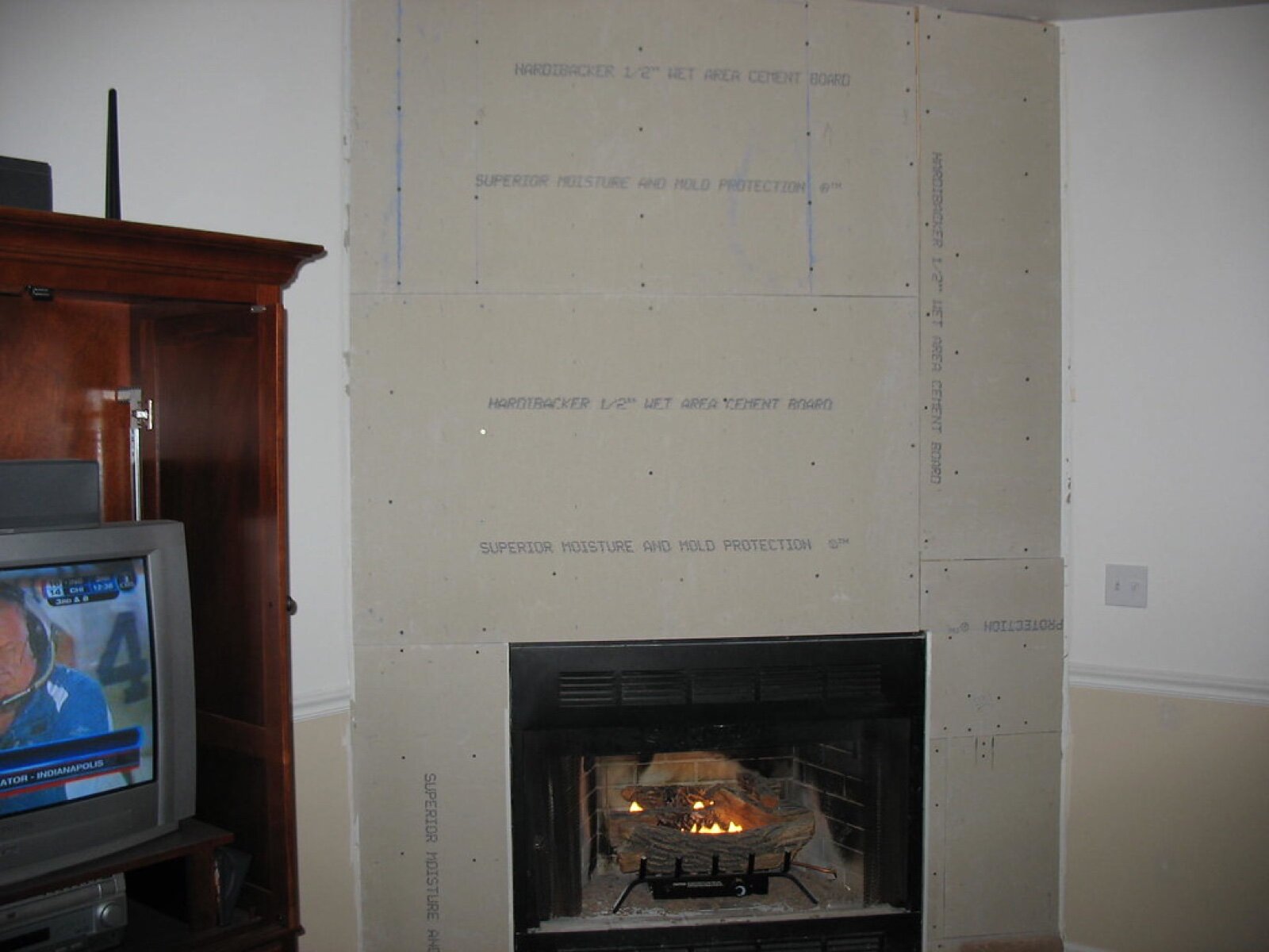 Cement backer board screwed over a fireplace surround with the screw pattern visible