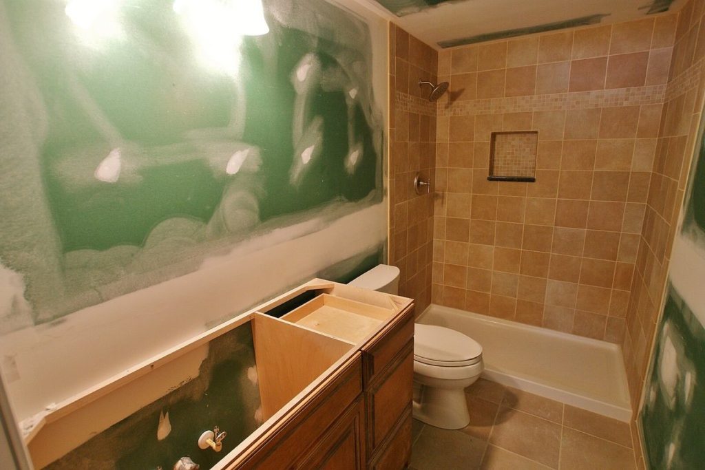 Bathroom mid-renovation with a tiled shower and bare walls